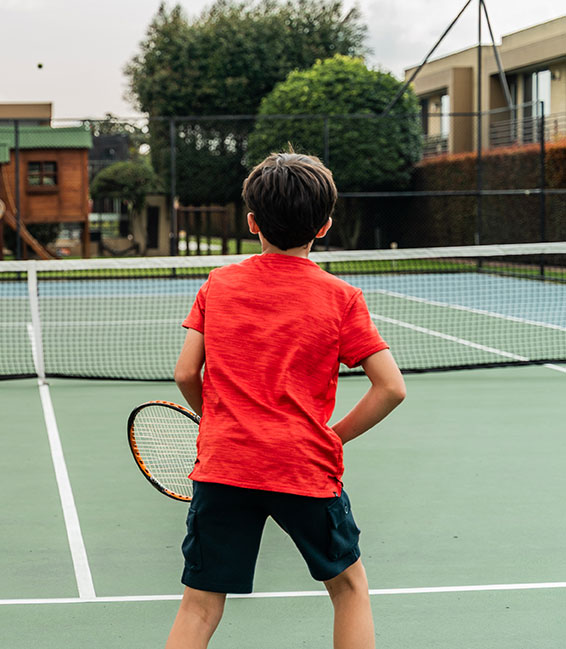 A kid playing tennis